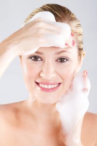 woman washing her face with a foam
