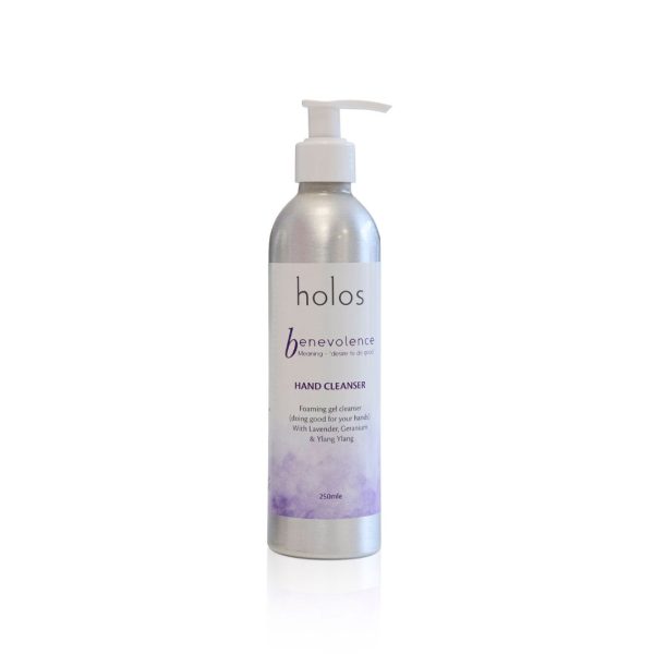 The silver bottle of Holos Skincare's Benevolence Hand Cleanser comes with a convenient pump dispenser. Its label, highlighted by purple accents, notes soothing lavender, chamomile, and ylang-ylang. With a 250ml capacity, it sits elegantly against a plain white background.